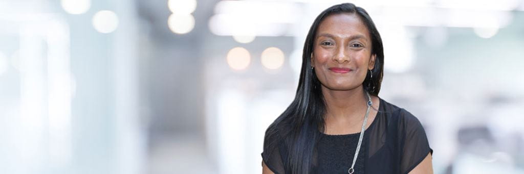 Indian female wearing a black dress smiling